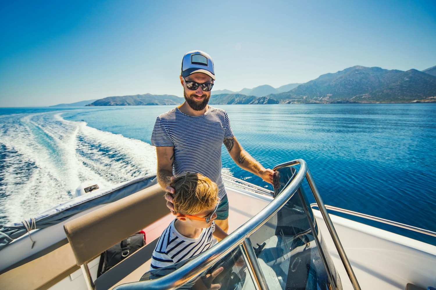 father and son sailing on a boat with fishing gear and safety equipment