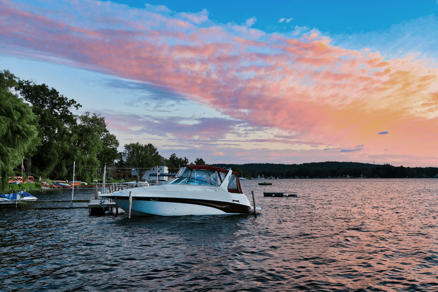 White powerboat docked at marina during golden hour sunset